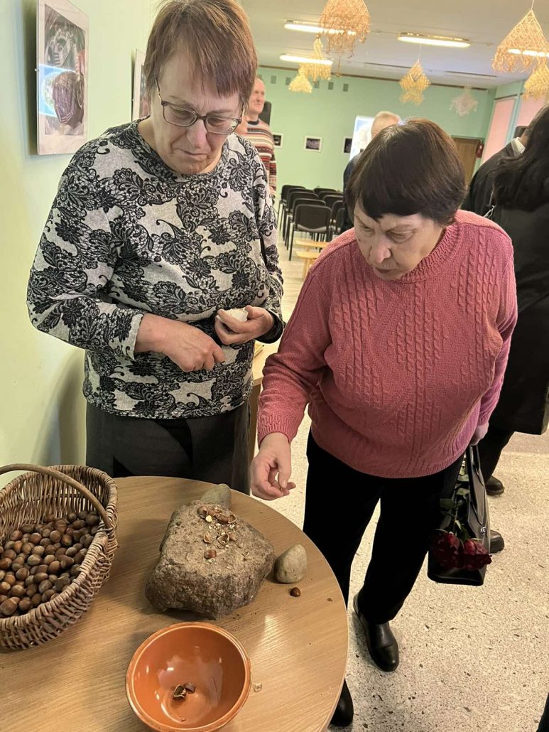 Aldona Mikštienė ir Liudmila Untanienė skanauja gliaudytų lazdyno riešutų.